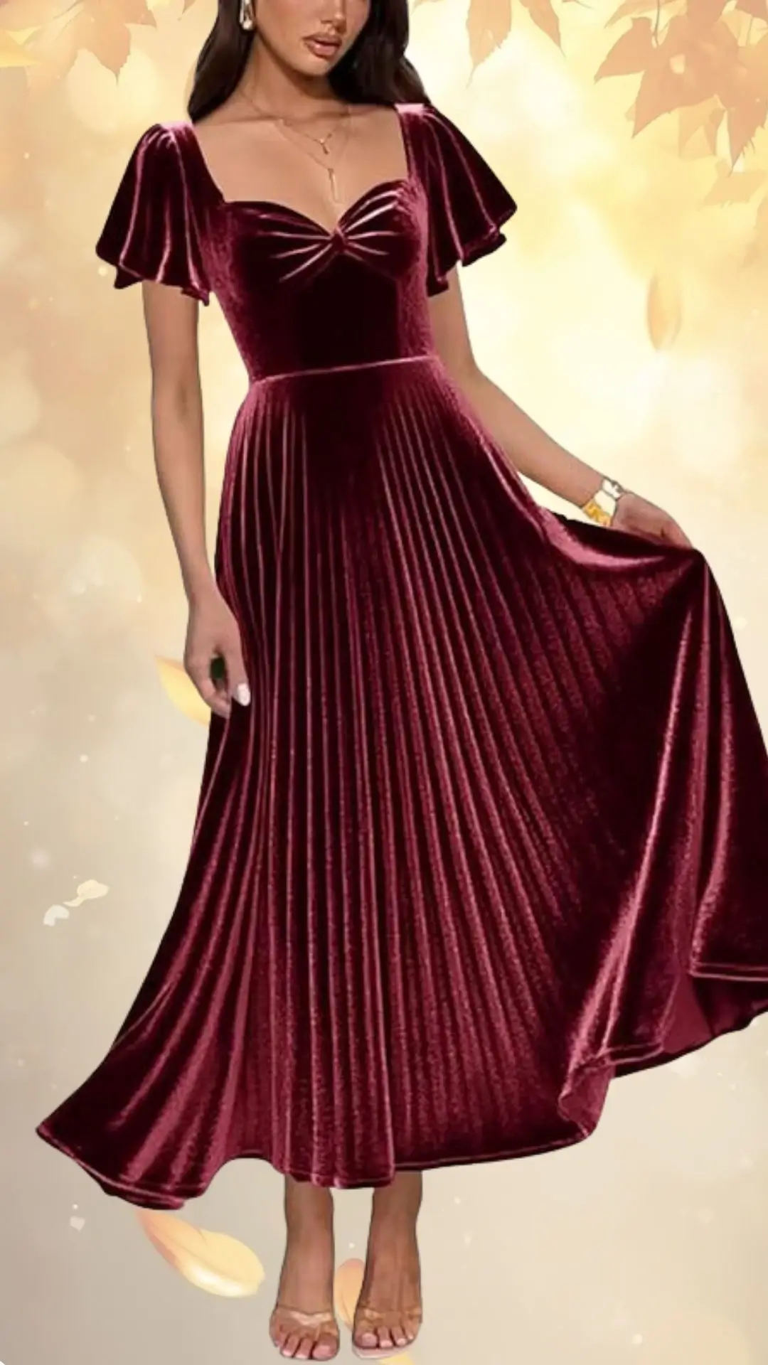 A luxurious burgundy dress made from soft velvet features short, puffed sleeves and a fitted bodice with a sweetheart neckline. The flowing skirt showcases elegant pleats that fall to the floor, creating a graceful silhouette ideal for formal occasions. Paired with neutral heels, the outfit exudes sophistication and warmth suitable for fall events.