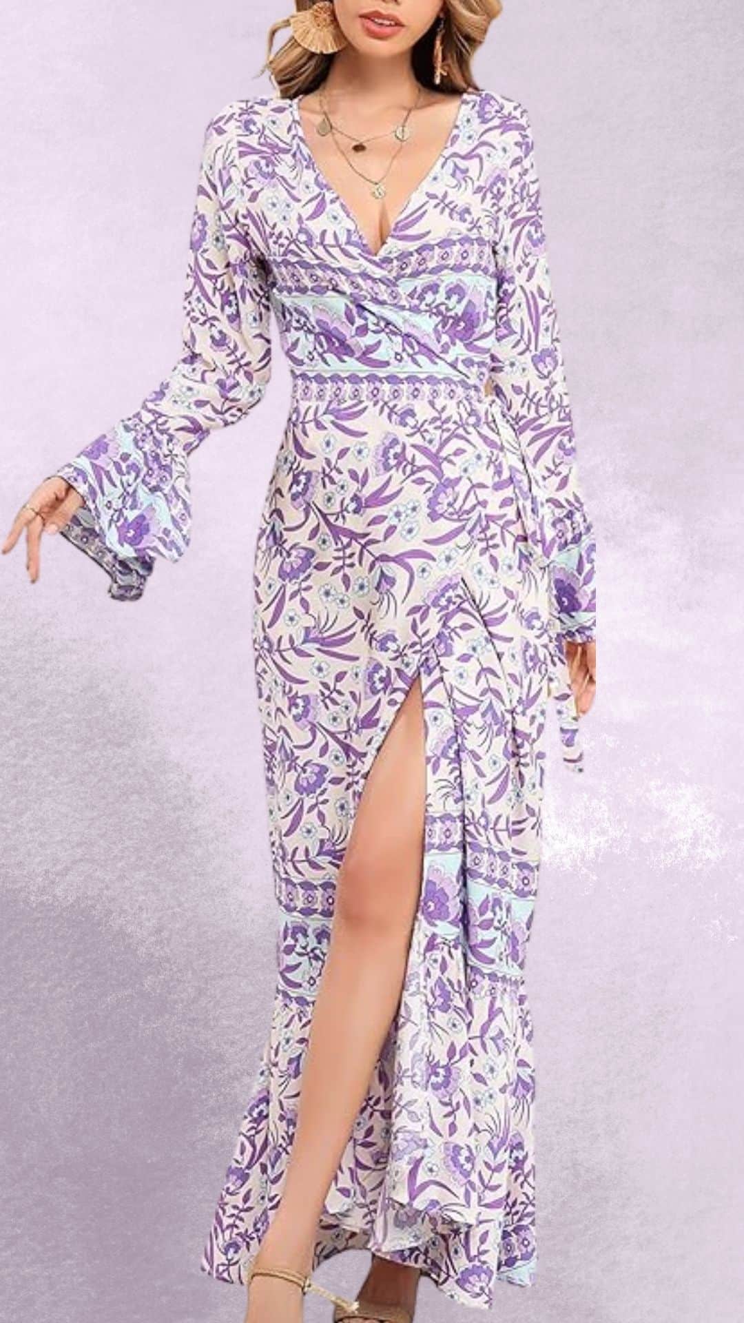 The dress features a flowing design with a wrap silhouette, adorned in a delicate floral print of lavender and soft blues on a light cream background. A plunging V-neckline and flared long sleeves enhance its elegance, while a side slit adds a touch of allure, making it versatile enough to pair beautifully with cowboy boots for a country western vibe.