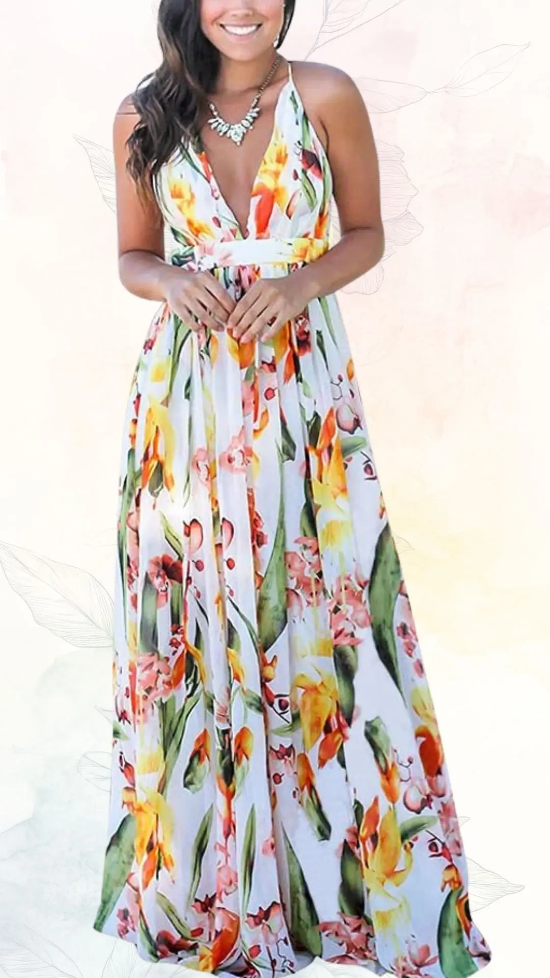 A summer maxi dress features a deep V-neckline and thin shoulder straps, adorned with vibrant floral patterns in shades of yellow, pink, and green against a white background. The dress flows elegantly to the floor, creating a light and airy silhouette, perfect for a wedding guest. A delicate necklace adds a touch of sophistication to the overall look.