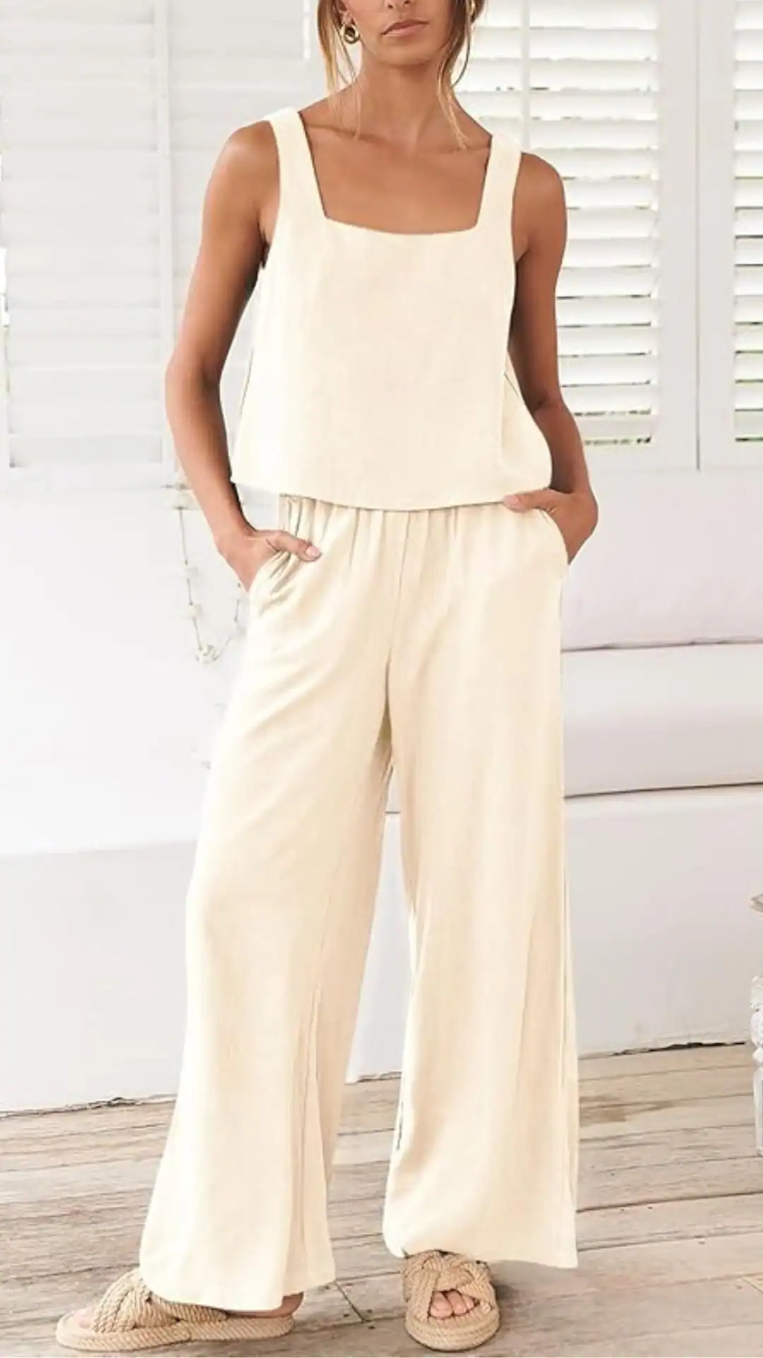 This outfit features a relaxed, sleeveless linen crop top with a square neckline paired with flowing, wide-leg linen pants, both in a soft, neutral ivory hue that exudes a minimalist and airy vibe. Ideal for casual outings or warm-weather gatherings, the ensemble showcases a lightweight texture that emphasizes comfort and effortless elegance.