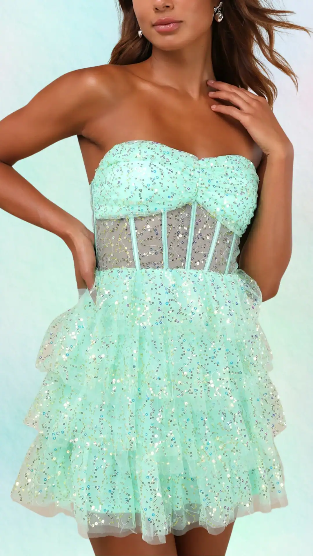 This vibrant, mint green homecoming dress features a strapless sweetheart neckline and a fitted bodice with a corseted design, complemented by layers of voluminous tulle that create a playful, flared silhouette. Adorned with shimmering sequins and delicate patterns, the overall vibe is whimsical and youthful, perfect for a formal event or school dance for teenage girls.