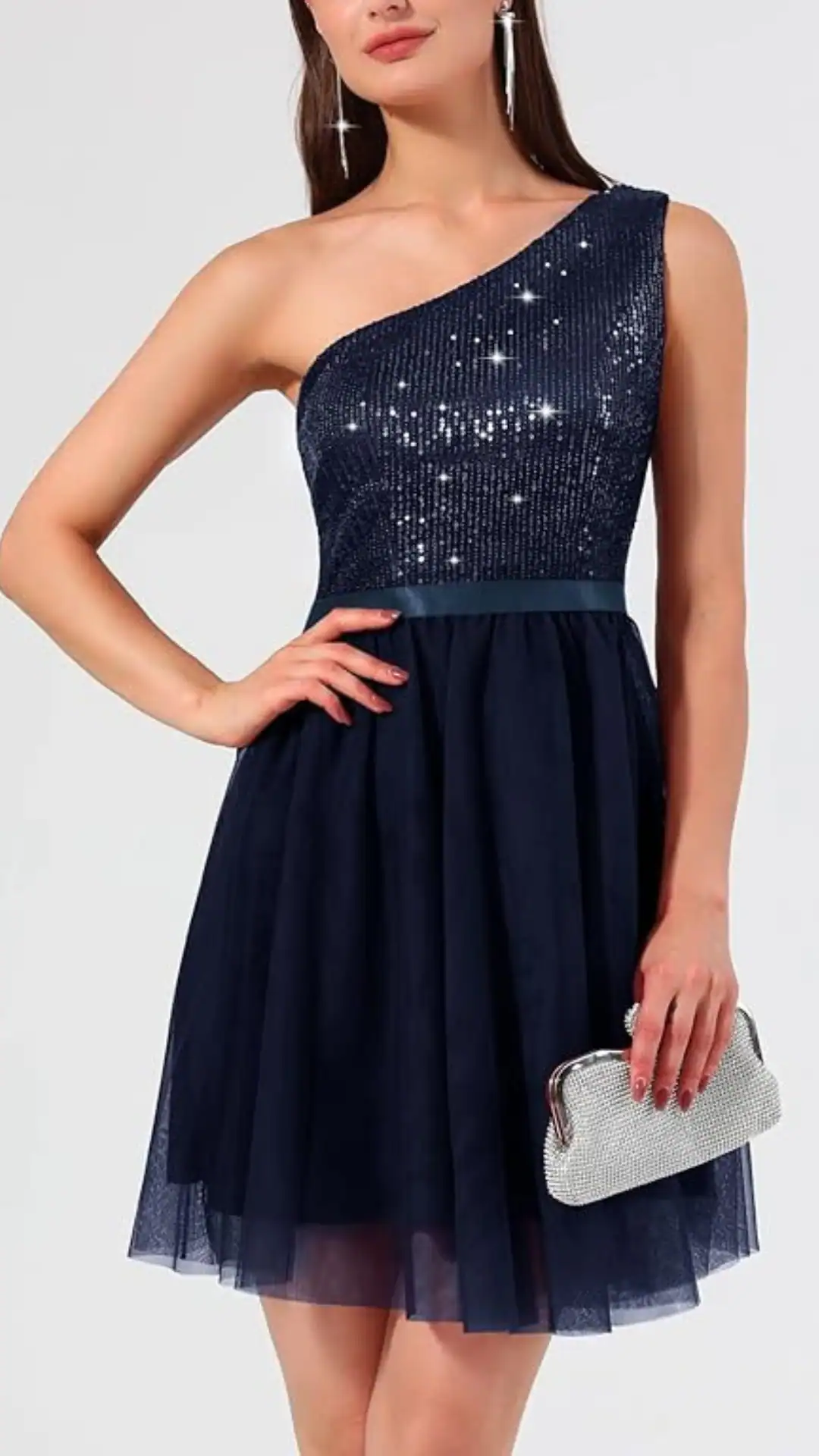 This one-shoulder homecoming dress features a fitted, sequined bodice in deep navy, transitioning to a voluminous tulle skirt that falls playfully above the knees. The overall vibe is elegant and chic, perfect for teenage girls attending formal events or school dances.