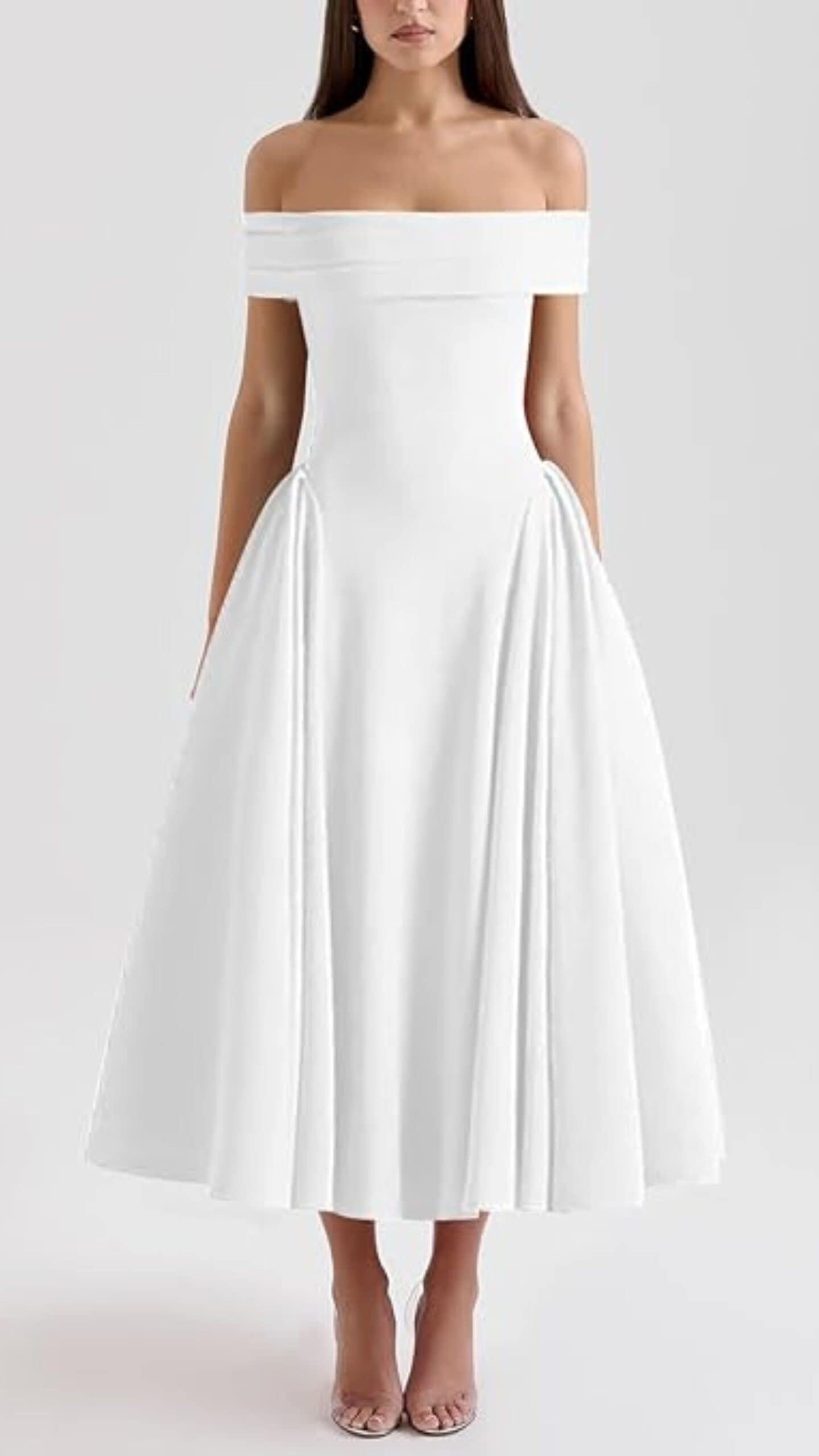 The dress features a fitted off-the-shoulder silhouette with a flattering A-line cut, crafted from a smooth, matte fabric that gives it an elegant appearance. In a crisp white color, this full-length gown showcases delicate pleating along the sides, exuding a classic and timeless vibe, making it suitable for formal occasions such as weddings or upscale events.