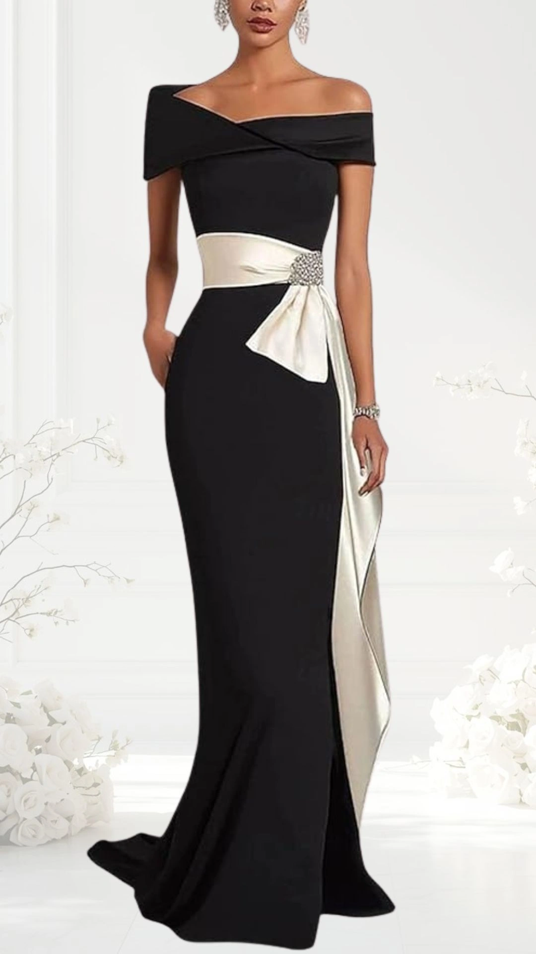 An elegant off-the-shoulder black wedding guest dress features a fitted bodice and a flowing skirt, accentuated by a wide ivory sash tied in a bow at the waist, adorned with a sparkling embellishment. The dress presents a sophisticated silhouette, blending timeless elegance with modern style. The background displays soft floral accents, enhancing the overall romantic atmosphere.