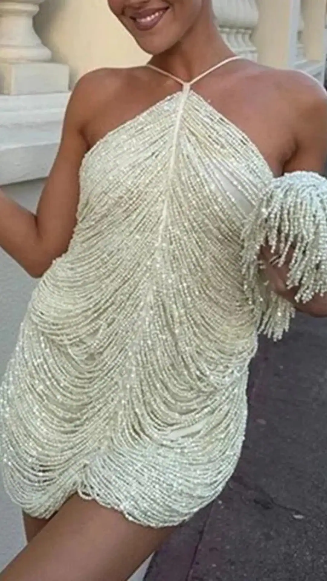 This homecoming dress features a striking off-white color adorned with cascading beadwork that creates a shimmering texture, giving it an ethereal vibe. The loose fit drapes elegantly over the body, making it suitable for formal school dances or parties, appealing to teenage girls seeking a chic and glamorous look.