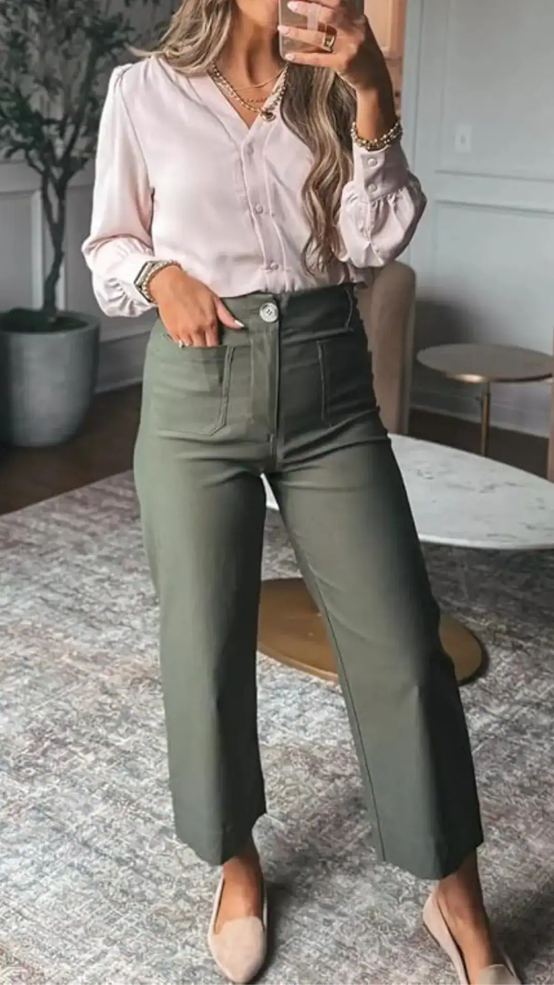 A fitted, high-waisted pair of olive green trousers presents a tailored, straight-leg silhouette that falls just above the ankle, featuring a matte cotton fabric for a smooth texture. The pants are styled with front pockets, a single button closure, and minimalistic design elements, exuding a modern and chic vibe suitable for casual outings or office wear.