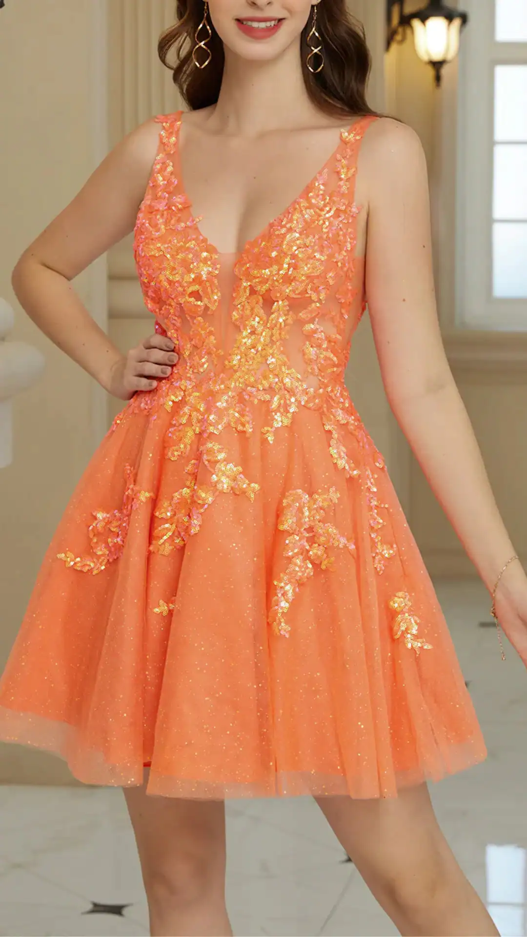 This enchanting orange homecoming dress features a shimmering, layered tulle fabric with subtle sparkle, complemented by intricate floral appliqués in lighter shades of coral. The dress showcases a fitted bodice with a deep V-neckline and a flared skirt that adds playful volume, creating a vibrant and youthful vibe perfect for a formal school dance or special event.