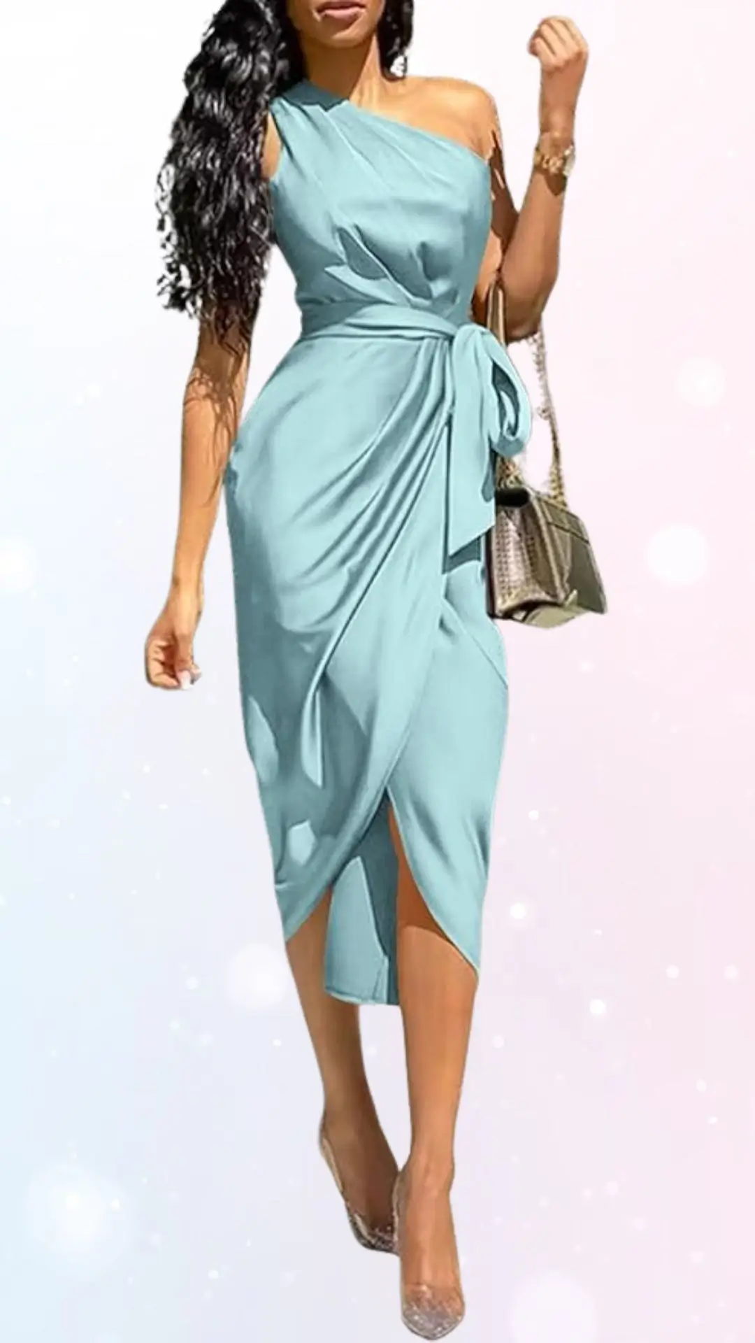 A flowing, pastel blue dress features a single shoulder strap and an intricately draped design, cinched at the waist with a matching tie. The dress has a chic side slit, adding elegance, and is paired with shimmering, transparent high heels. A stylish handbag completes the look, enhancing the overall sophisticated appearance suitable for a spring wedding.