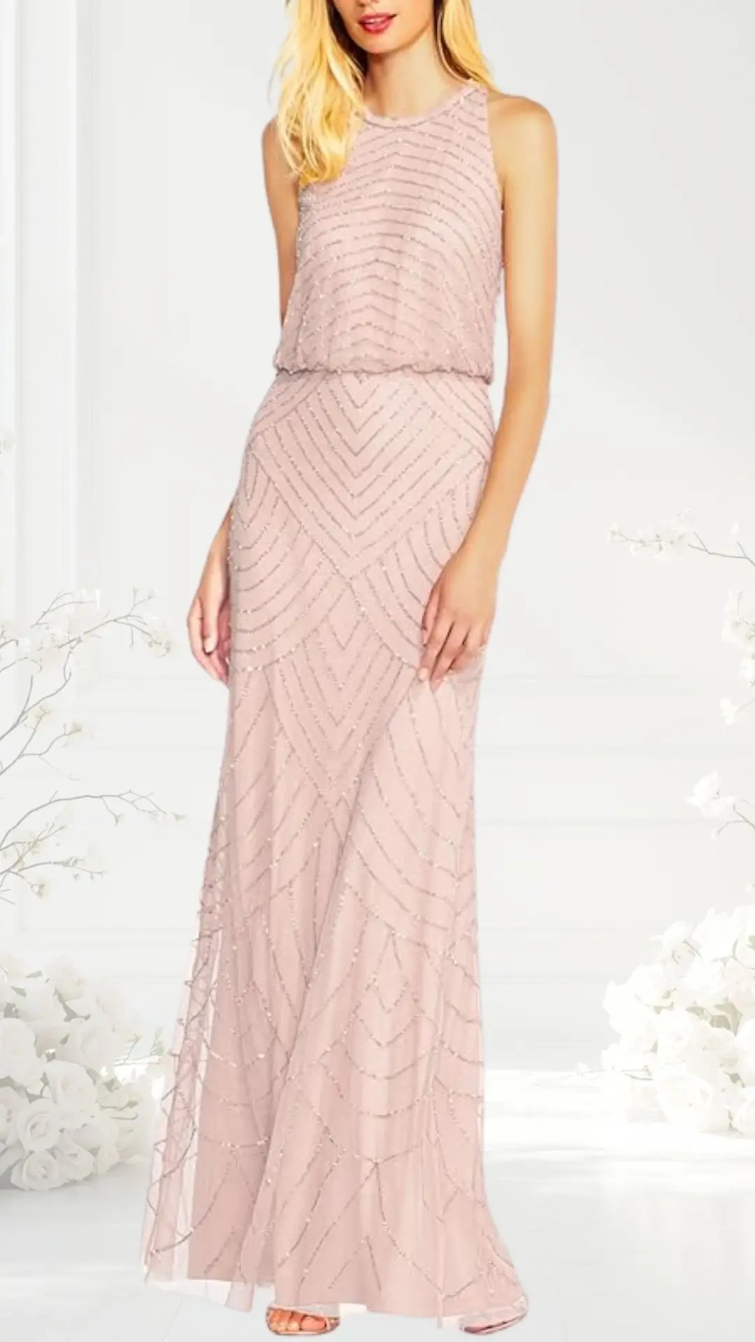 A blush pink wedding guest dress features a sleeveless design with a round neckline, crafted from a slightly sheer fabric adorned with intricate bead and sequin details in a chevron pattern. The floor-length skirt flows elegantly from a fitted waist, creating a graceful silhouette ideal for formal occasions.