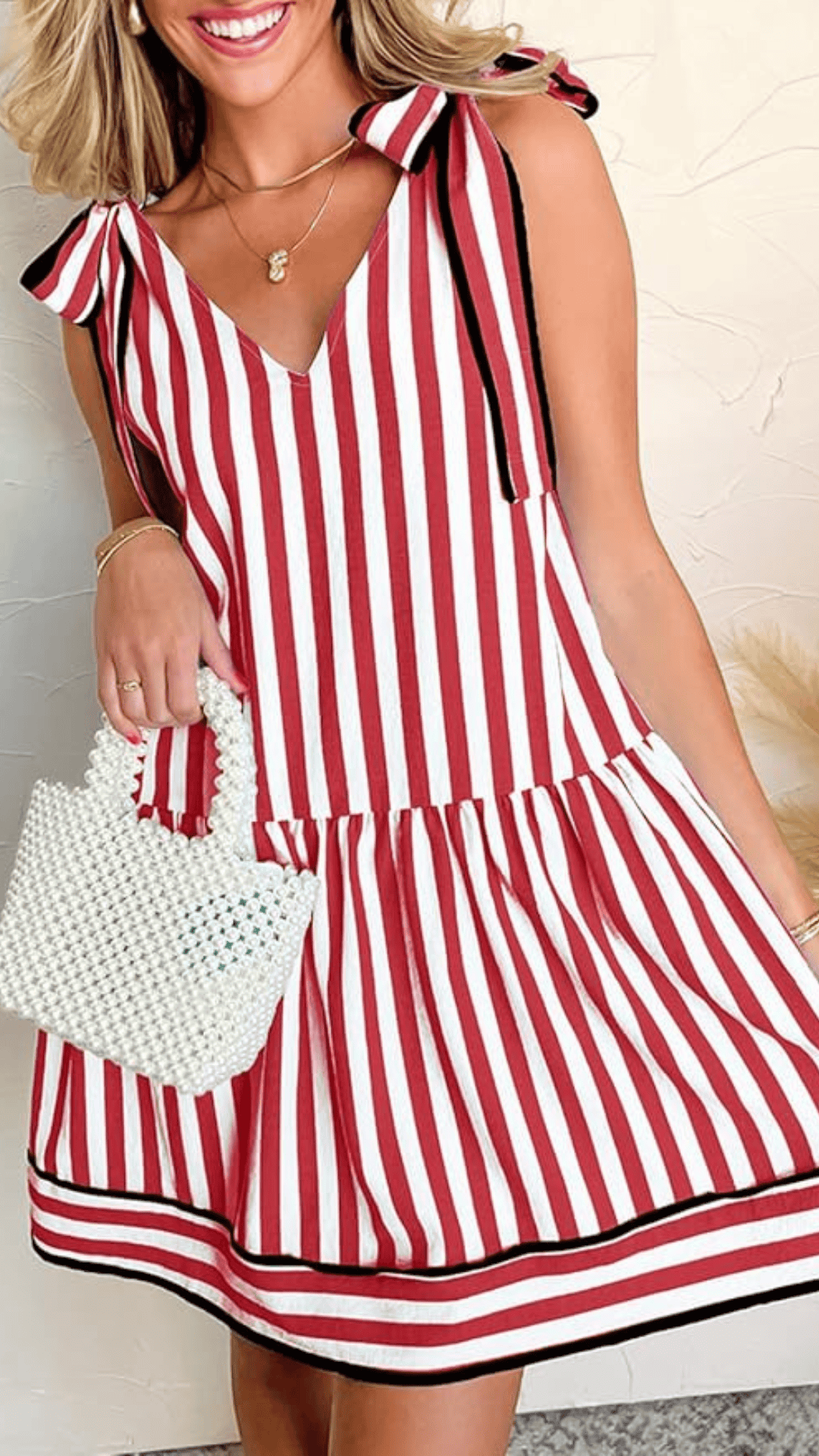This playful red and white striped dress features a V-neckline, bow-tied shoulder details, and a flared skirt, creating a classic yet youthful look. Made from a lightweight fabric with a textured finish, it exudes a cheerful and festive vibe, perfect for casual Fourth of July celebrations.