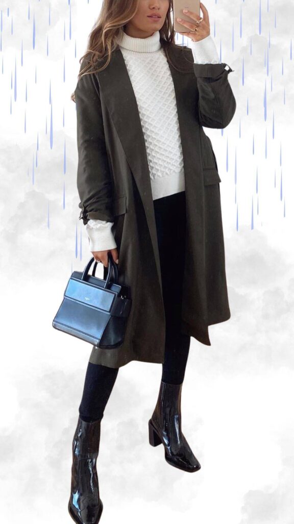 The outfit features a sophisticated olive green long coat layered over a textured white turtleneck sweater, creating a chic and cozy look. Black high-waisted leggings provide a sleek base, complemented by shiny black ankle boots that add a polished touch. A structured black handbag completes the ensemble, making it ideal for staying warm and stylish in rainy fall and winter weather.