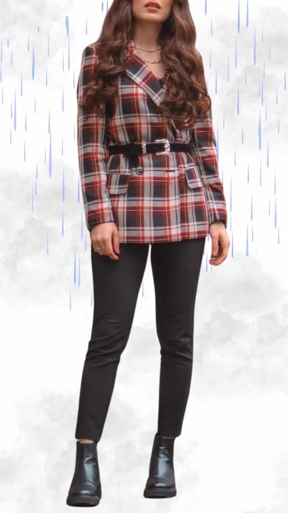The outfit features a chic plaid blazer with a fitted silhouette in hues of red, white, and navy, complemented by a black belted waist for added structure. Underneath, the look includes sleek black leggings that offer comfort and style, paired with stylish black ankle boots with a glossy finish to keep feet dry. The ensemble is topped off with delicate layered necklaces, merging elegance with practicality for a classy rainy day outfit.