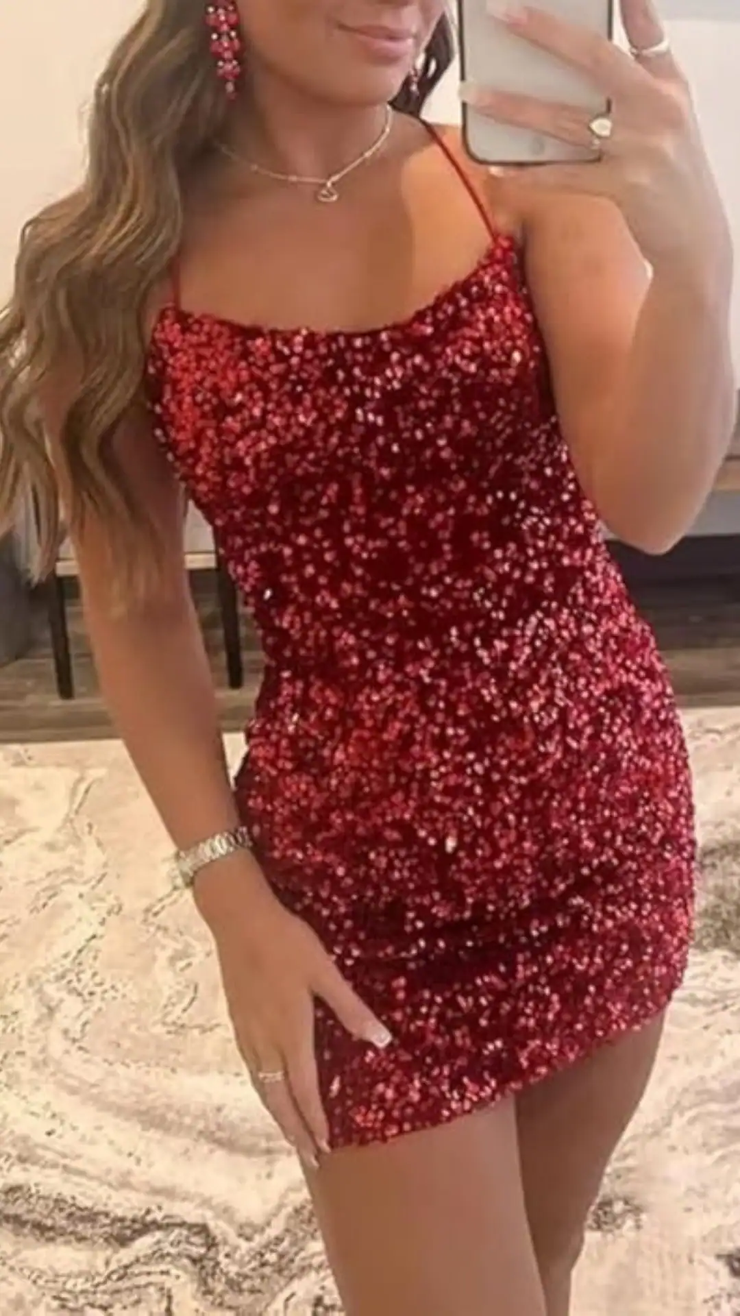 This form-fitting red homecoming dress features a textured fabric adorned with scattered sequins, creating a sparkling effect. The sleeveless design highlights a youthful, glamorous vibe, making it perfect for a festive occasion like homecoming, appealing to teenage girls seeking a bold and eye-catching look.