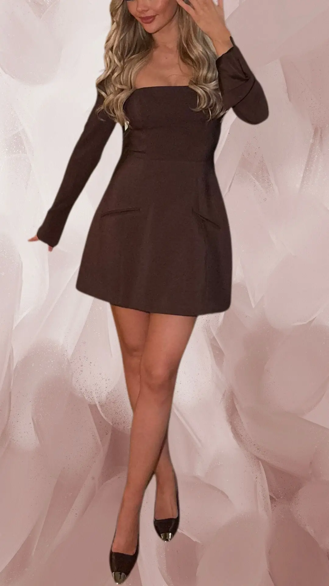 The outfit features a short, fitted brown dress made from a smooth, structured fabric, with long sleeves and a square neckline. It is complemented by sleek, brown shoes with metallic tips, enhancing the overall elegant look. Subtle pockets on the dress add a practical touch to this stylish ensemble.