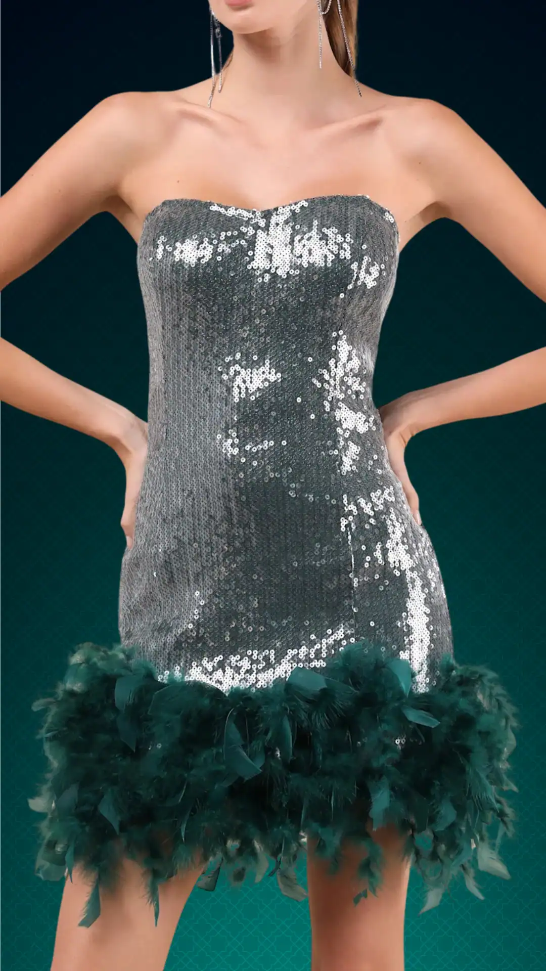 The dress features a fitted, strapless silhouette adorned with shimmering silver sequins, transitioning into a playful, voluminous emerald green feathered hem. Its vibrant color and bold texture create a glamorous, eye-catching look, suitable for a homecoming or formal dance, perfect for a trendy teenage girl.