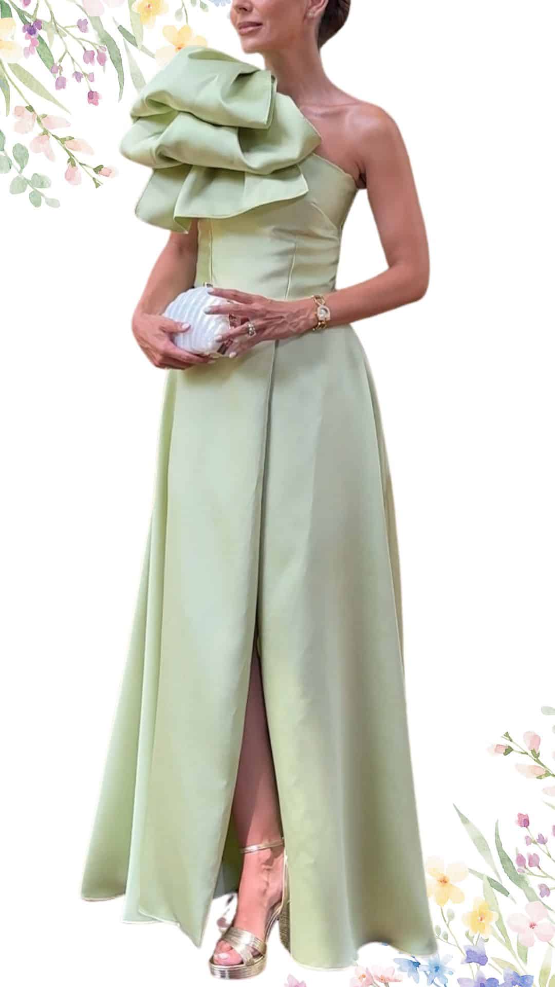 This elegant spring wedding guest dress features a soft, pastel green hue and a structured, strapless design. It showcases a dramatic ruffled detail on one shoulder, flowing into a floor-length skirt with a subtle front slit for movement. The smooth satin texture enhances its sophisticated allure, making it a perfect choice for a formal occasion.