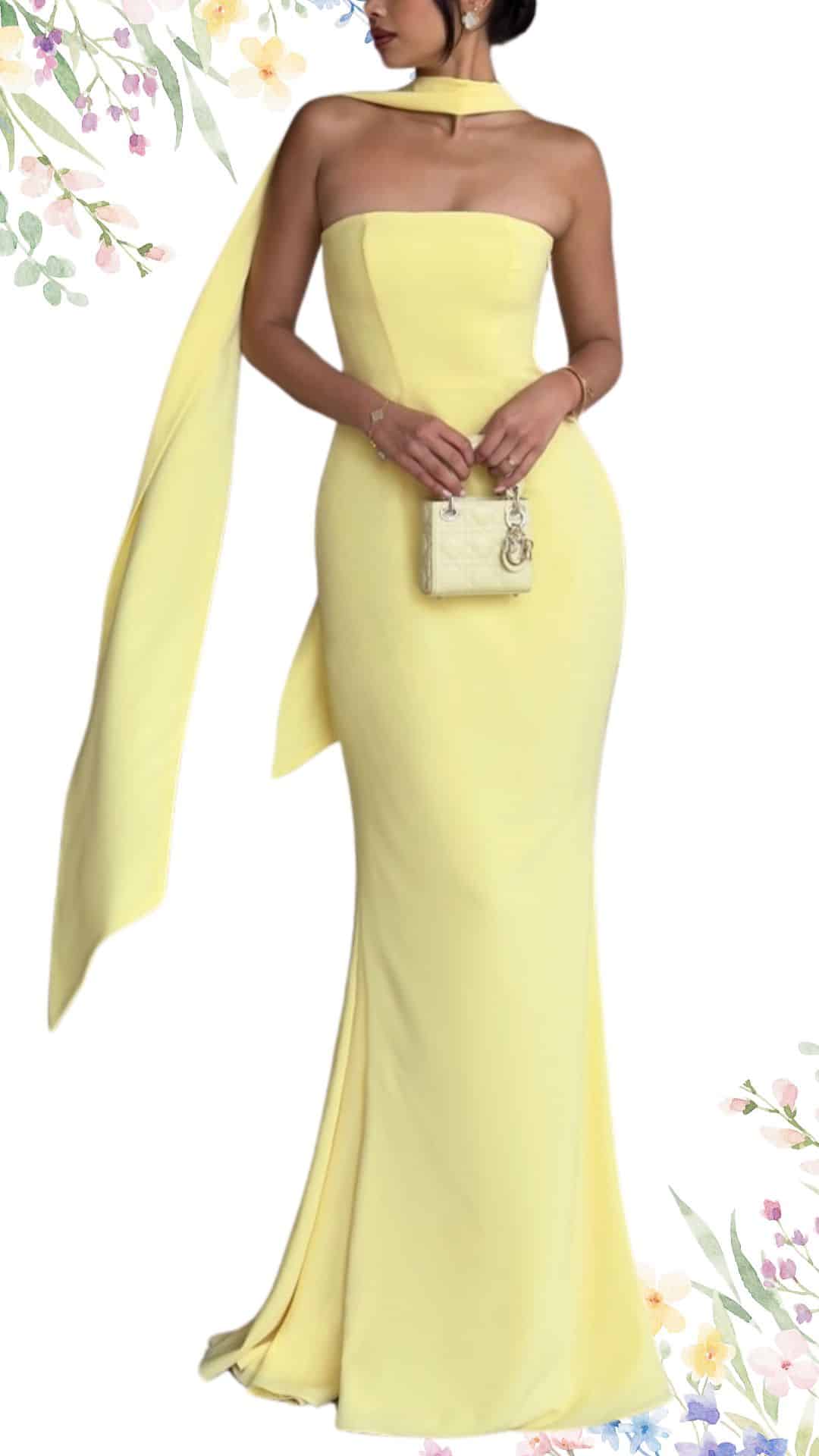 The dress is a strapless, floor-length gown in a soft pastel yellow, featuring a fitted bodice that accentuates the silhouette. It has a sleek, straight neckline, delicate draping at the back, and a subtle flared hem that adds elegance. The smooth texture enhances its classy appeal, making it a perfect choice for a spring wedding.