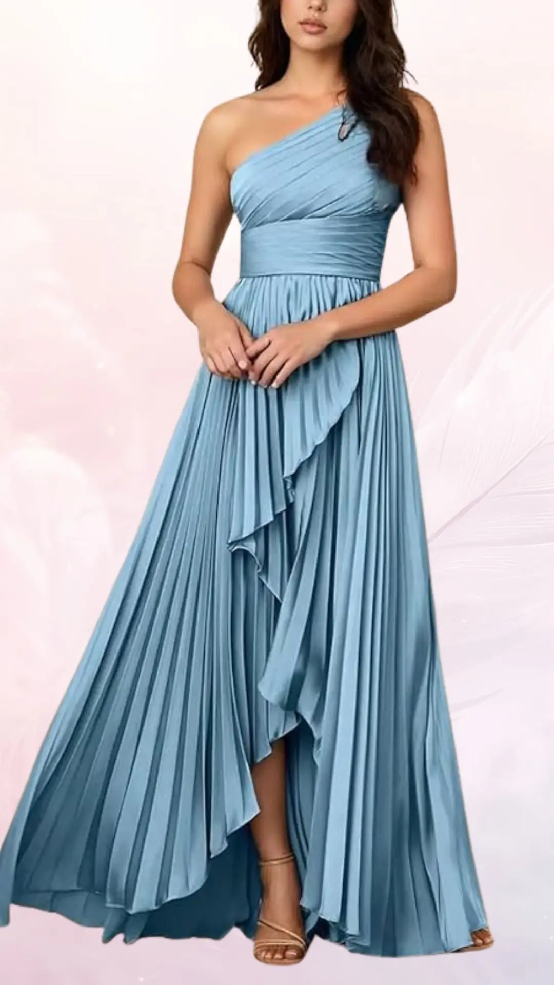 A flowing, lightweight dress in soft blue features a one-shoulder design with elegant pleats cascading down the skirt. The dress cinches at the waist and incorporates a ruffled layer that adds movement and sophistication, complemented by strappy, open-toe heels.