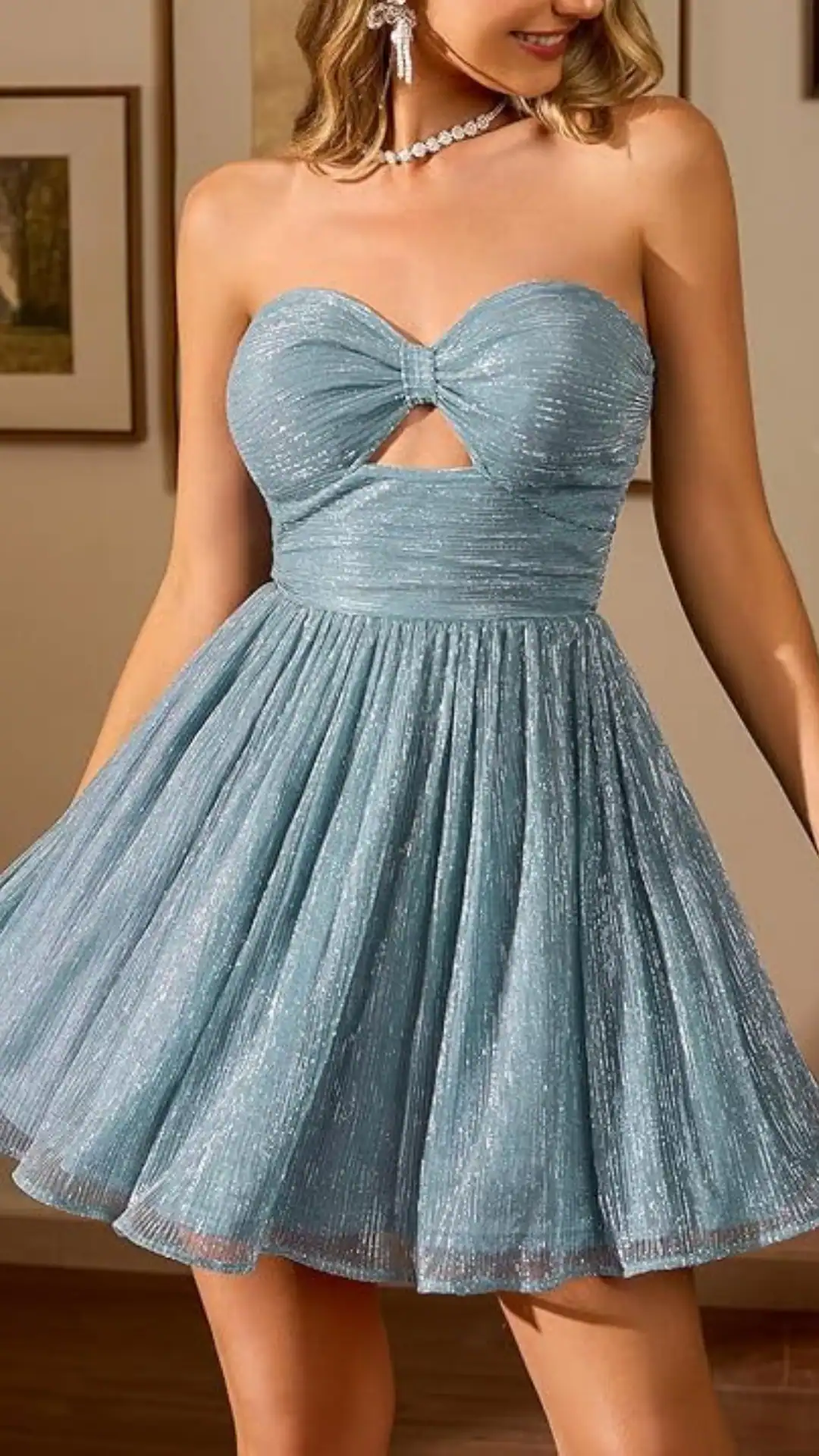 This strapless homecoming dress features a shimmering, textured fabric in a soft teal color. Designed with a fitted bodice and a playful voluminous skirt that flares out, it embodies a charming and youthful vibe perfect for a festive occasion like a school dance or party.