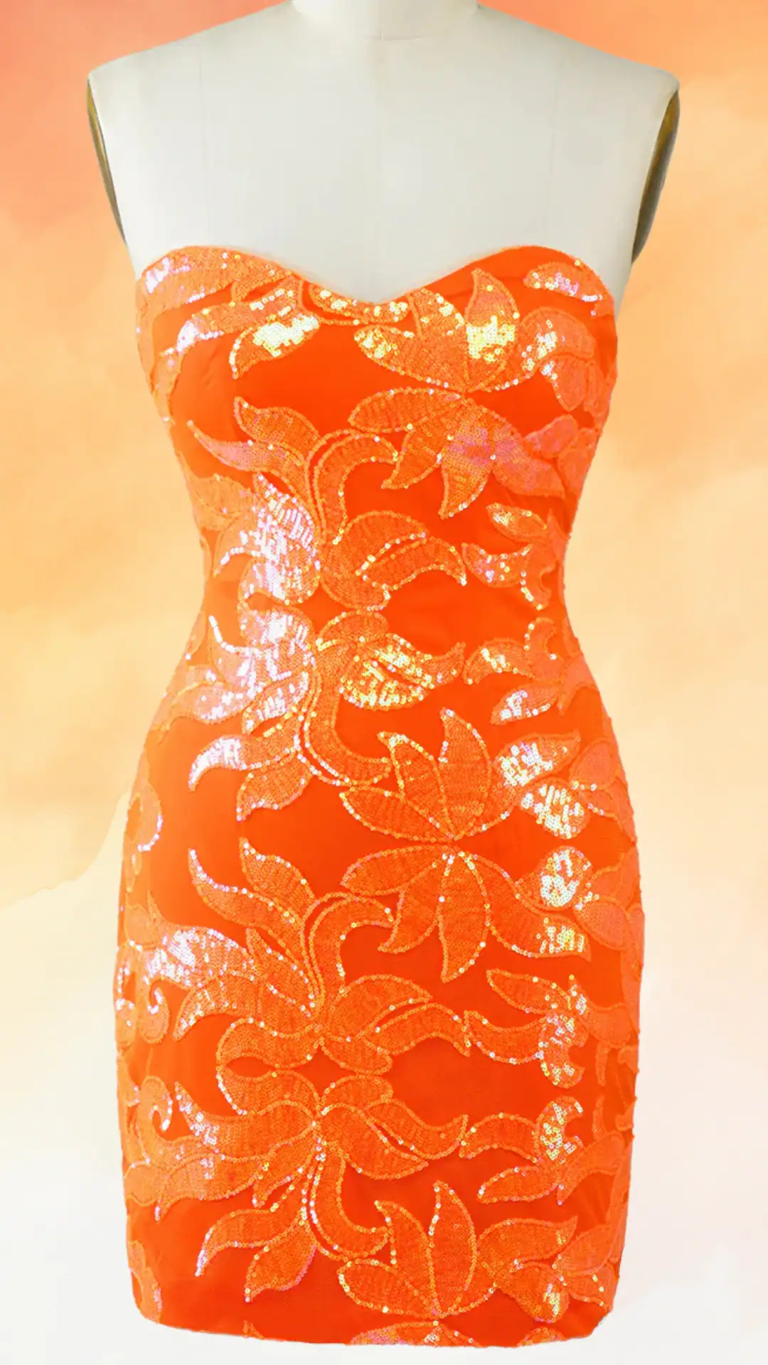 This vibrant orange homecoming dress features a form-fitting, strapless silhouette adorned with intricate sequin floral patterns that add a shimmering texture. With its bold hue and sheer, glimmering overlay, it exudes a trendy and fun vibe, making it perfect for a spirited school dance or special occasion aimed at teenage girls.