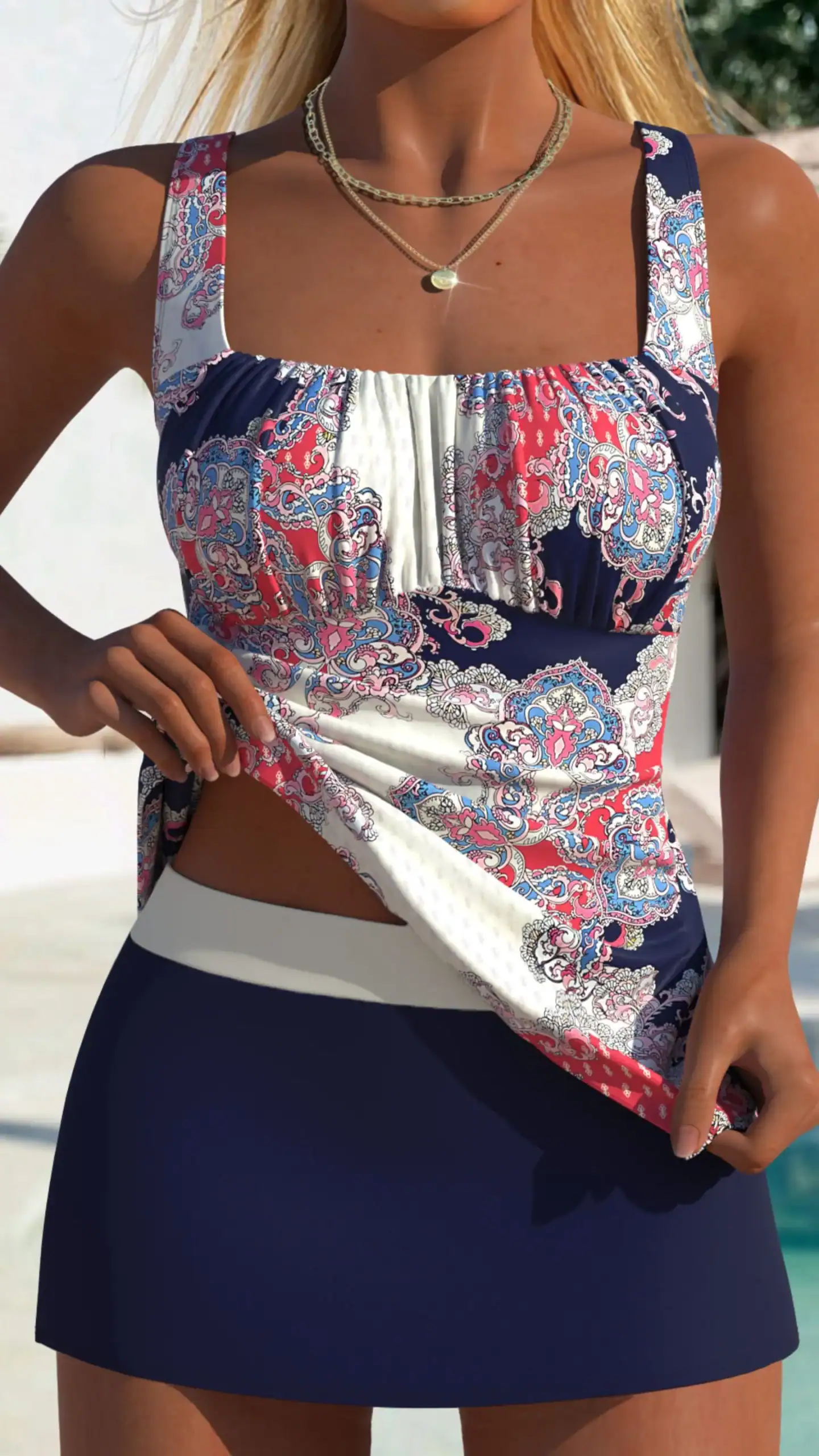 This tankini features a fitted, crop-style top with wide straps, highlighting a playful and vibrant paisley print in shades of navy, pink, and white, paired with a sleek, navy mini skirt for a coordinated look. Made from a smooth, stretchy fabric, it combines comfort with a stylish, relaxed vibe, perfect for casual beach outings or poolside relaxation.