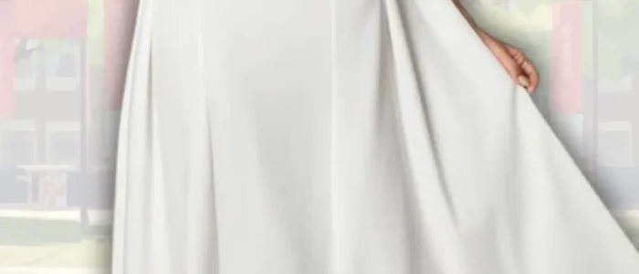 white-graduation-dress-with-off-shoulder-silhouette-2025-12-14T01:17:39.000Z A flowing white off-shoulder graduation dress features a fitted bodice that transitions into a softly flared skirt. The dress is complemented by the elegant silhouette created by vertical seams, while the model wears delicate strappy heels. The background includes hints of a campus setting, suggesting a celebratory atmosphere.