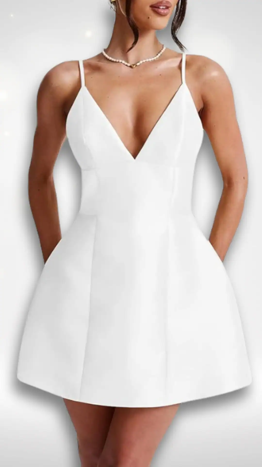 This white homecoming dress features a sleek, minimalist design with a deep V-neckline and delicate spaghetti straps, crafted from a smooth, structured fabric that creates a streamlined silhouette. The flared skirt offers a playful volume, making it perfect for a romantic and youthful vibe, ideal for formal occasions like homecoming or school dances for teenage girls.