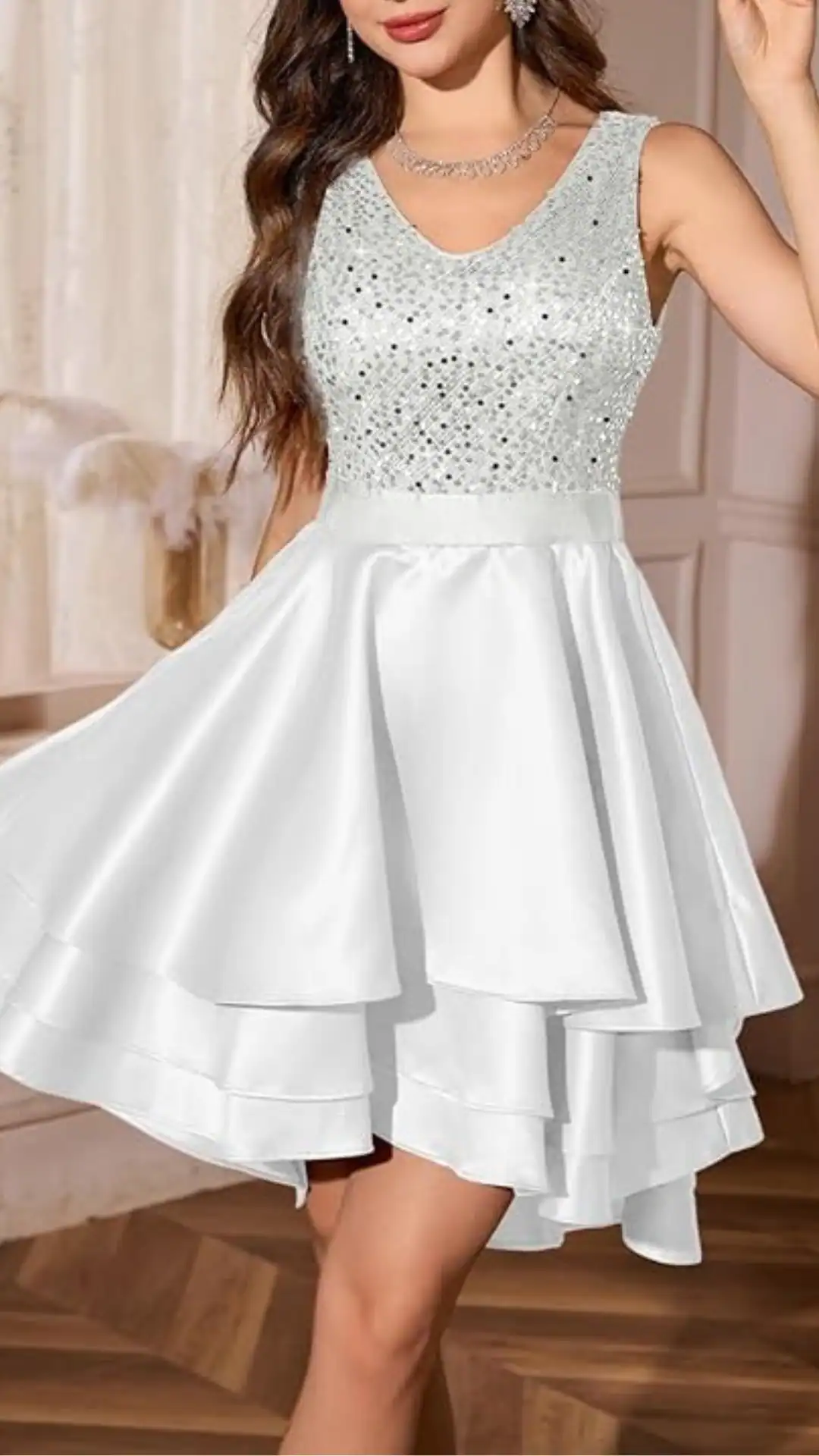 This white homecoming dress features a fitted, beaded bodice that shimmers, paired with a playful tiered satin skirt that falls gracefully with volume. The overall vibe is youthful and romantic, making it ideal for formal events like homecoming or school dances, designed specifically for teenage girls.