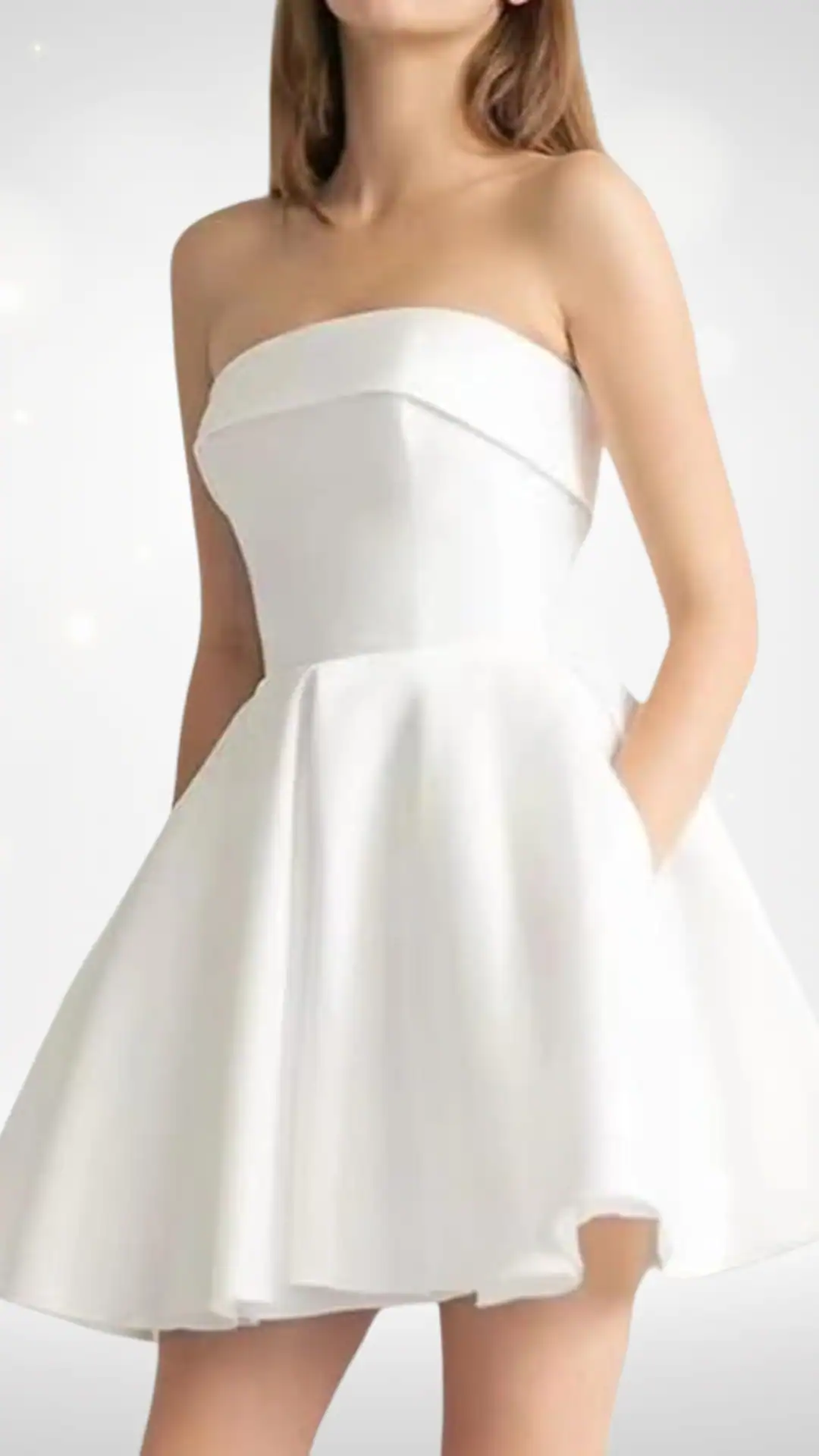 This white homecoming dress features a structured strapless bodice that seamlessly transitions into a flared skirt, offering a playful yet elegant silhouette. Crafted from a smooth, slightly glossy fabric, the dress exudes a fresh, modern vibe, making it perfect for teen events like homecoming or school dances.