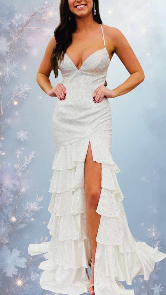 This elegant winter formal dress features a deep V-neckline and thin shoulder straps, accentuating its form-fitting silhouette. The dress is adorned with shimmering beadwork and boasts a cascading ruffle hem, complemented by a thigh-high slit for added allure. Its soft white color enhances its chic appearance, making it a stylish choice while ensuring warmth and sophistication.