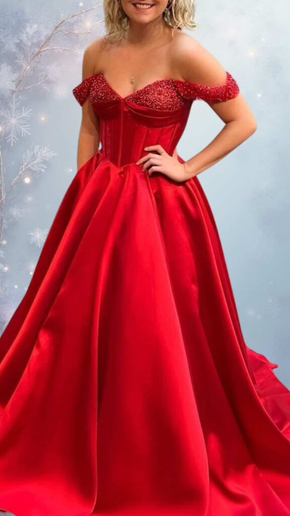 A vibrant red off-the-shoulder evening gown features a structured bodice adorned with shimmering beadwork and a flowing, full skirt that elegantly drapes to the floor. The soft satin fabric offers a luxurious sheen, while the gown's design ensures a chic and warm option for winter events. This dress embodies a balance of cute and classy.