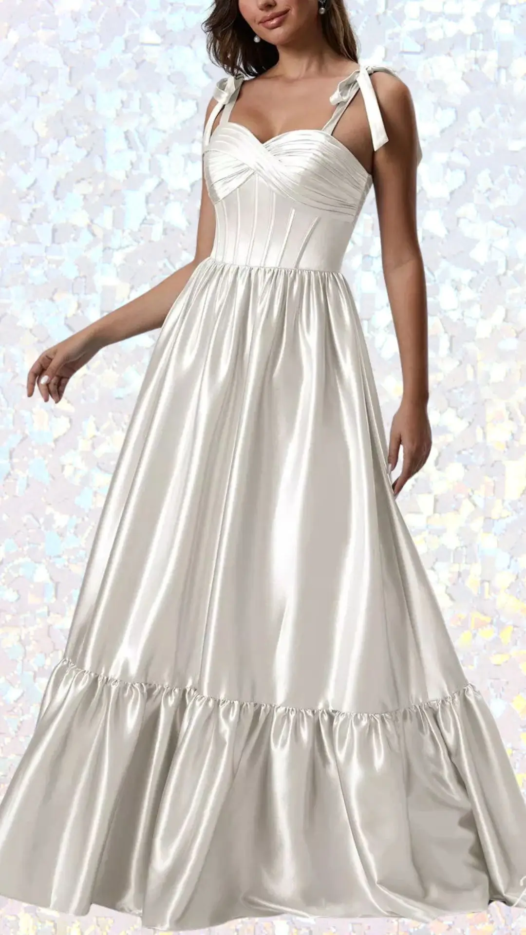 The dress is a long, elegant white gown made of a smooth satin fabric with a soft sheen. It features a sweetheart neckline, delicate tie straps, and a flowing skirt that gently gathers into a flared hem, adding a touch of romantic sophistication. The combination of textures and the luxurious fabric makes it an ideal choice for a winter formal event.