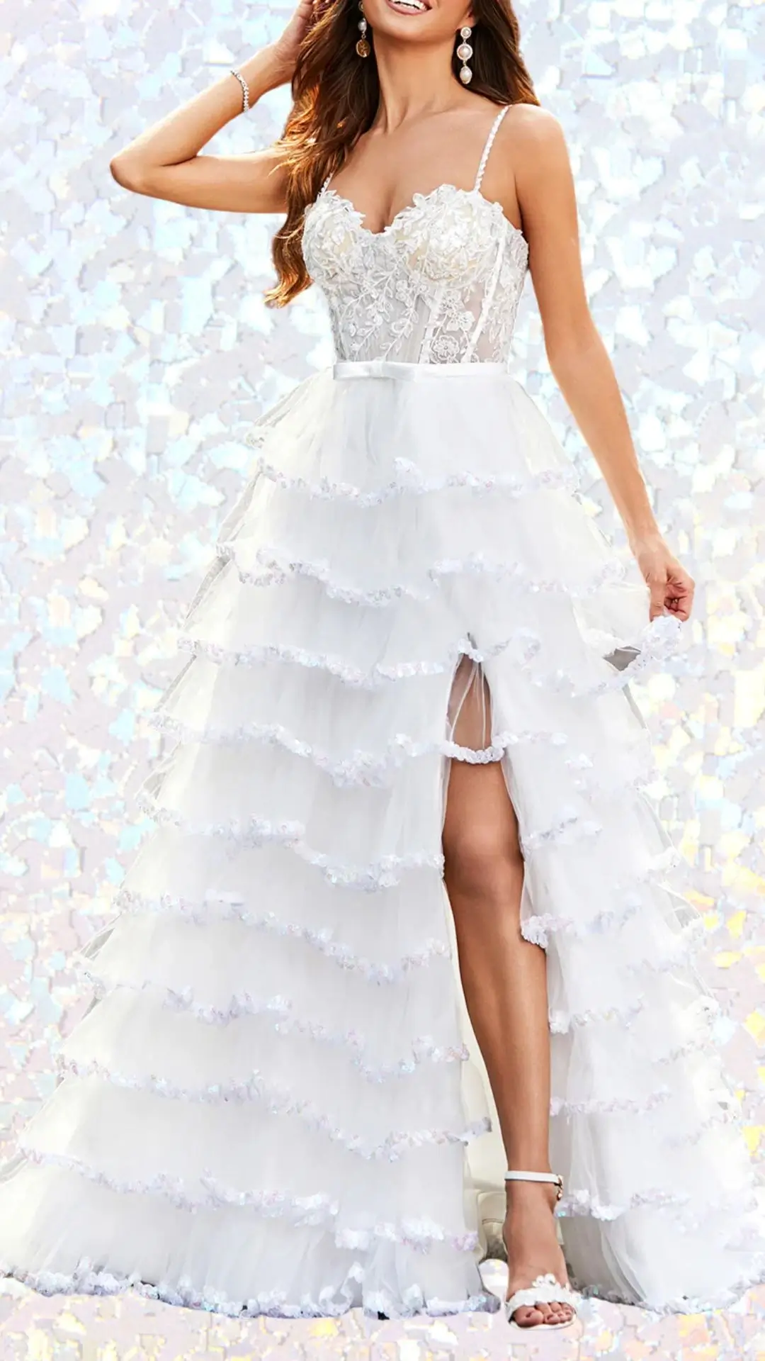 This long white winter formal dress features a fitted, lace bodice adorned with delicate floral appliqués, complemented by thin spaghetti straps. The flowing skirt is layered with soft, ruffled tiers, accented with shimmering sequins and a stylish slit for added elegance. The ethereal design, paired with a scalloped hem, makes it a stunning choice for a school winter formal.