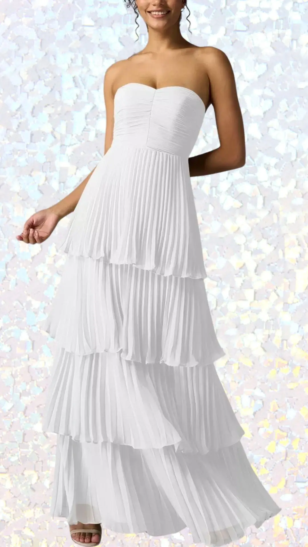 This long white winter formal dress features a strapless bodice with softly gathered fabric and cascading tiered pleats that create a flowing silhouette. Made from a lightweight material, it exhibits a sleek, smooth texture with subtle movement, ideal for an elegant occasion. The layered design adds dimension, enhancing the dress's graceful and sophisticated appeal.