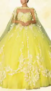 This yellow quinceañera dress features a strapless sweetheart neckline adorned with intricate floral appliqués, complemented by a matching sheer cape that drapes gracefully over the shoulders. The voluminous ball gown silhouette showcases layers of soft tulle that create a vibrant skirt, embellished with delicate white floral patterns that enhance its overall elegance and texture. The soft, sunny hue of yellow contrasts beautifully with the white details, making it a standout choice for a celebration.