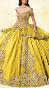 This exquisite yellow quinceañera dress features an off-the-shoulder sweetheart neckline accented with intricate lace and beadwork. The gown has a voluminous, layered skirt with a dramatic hemline, embellished with ornate silver floral appliqués that add a touch of elegance. The rich yellow fabric harmonizes beautifully with the shimmering silver details, creating a striking and regal appearance.