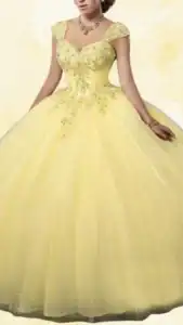 This yellow quinceañera dress features a fitted bodice with a sweetheart neckline and delicate cap sleeves, adorned with shimmering embellishments. The full, voluminous skirt flows elegantly to the floor, crafted from soft tulle that catches light with scattered sparkles, creating a whimsical and celebratory look. The overall hue is a vivid, cheerful yellow, perfect for a festive occasion.